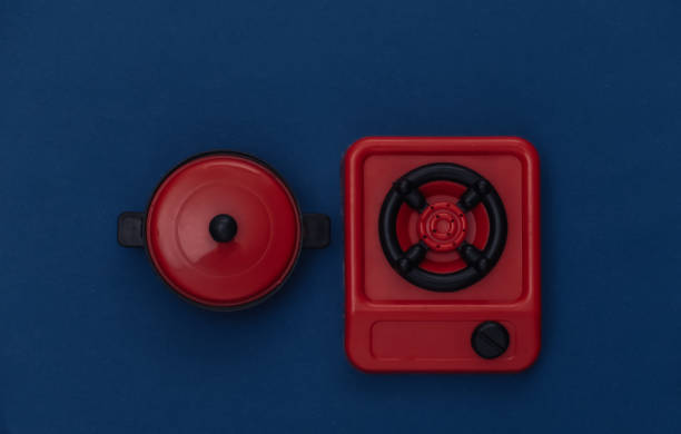 istock Toy stove and pan on classic blue background. Color 2020 1318099357