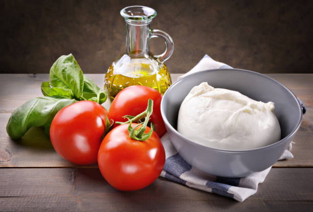 istock Mozzarella, tomatoes, basil and extra virgin olive oil on wooden table. 1318099709