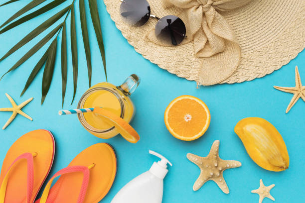 istock Flat composition with beach holiday accessories and fruits on blue background with copy space, summer background 1318108115