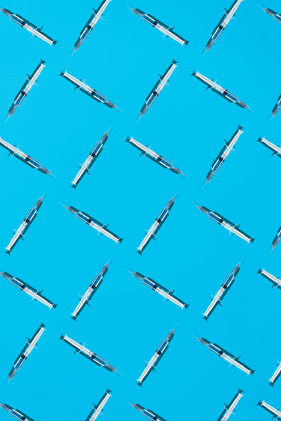 istock Patterm with COVID-19 vaccine on a blue background 1318108180
