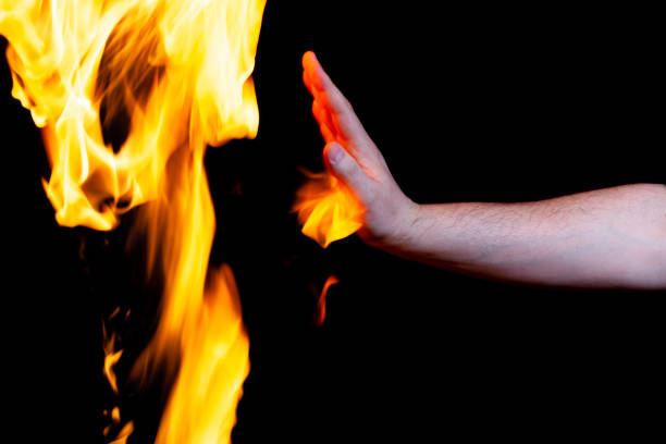 istock mans hand touches the flame, place under the text 1318110029