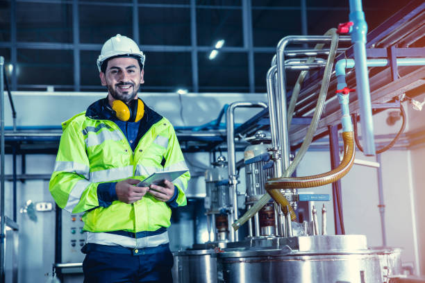 istock Happy engineer male worker working in factory using tablet computer to check boiler water pipe in factory, portrait smile. 1318110838