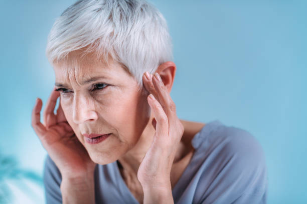 Senior Woman Suffering From Tinnitus Senior woman suffering from tinnitus or ringing in her ears. ear stock pictures, royalty-free photos & images