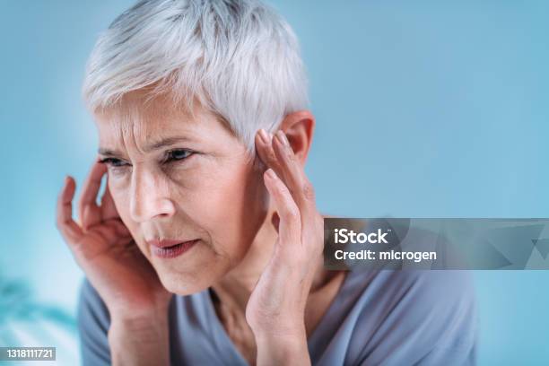 Senior Woman Suffering From Tinnitus Stock Photo - Download Image Now - Tinnitus, Ear, Ringing