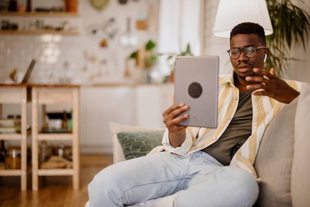 Young man having online mental health session Young African man using telemedicine to seek mental health services in an increasingly virtual world. Communicates remotely virtual event stock pictures, royalty-free photos & images
