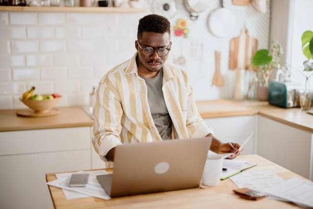 istock Young man does online stock trades at home 1318114524