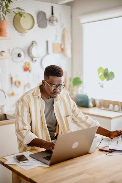 istock Young man does online stock trades at home 1318114534