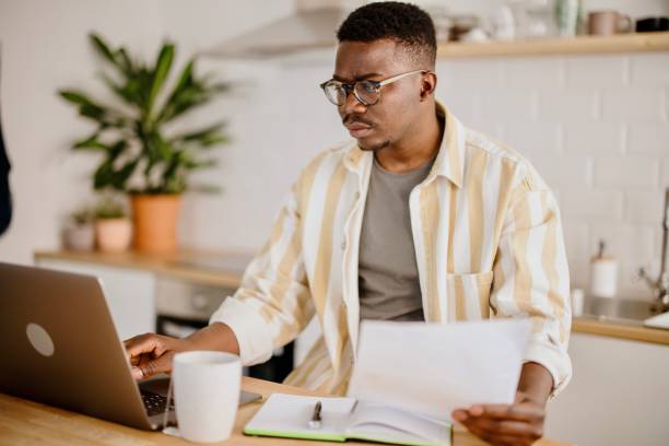 istock Young man does online stock trades at home 1318114637