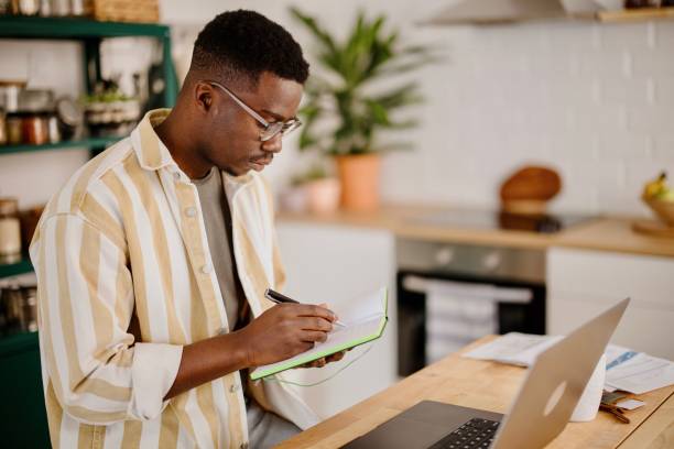 istock Young man uses a laptop to work from home 1318114726