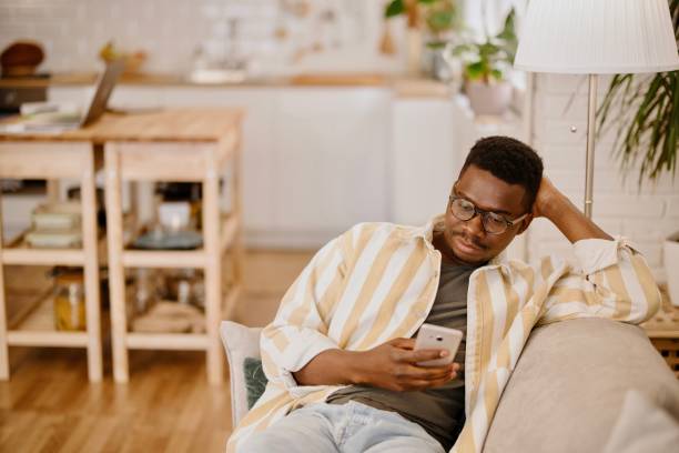istock Young man using online dating app while relaxing at home. 1318114817