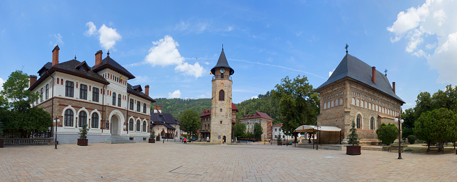 Piatra Neamț, Romania - July 25, 2019: Central Plaza, from left to right with 3 points of interest: Museum of Arts, Stephen the Great's Tower and Royal Court's Birth of Saint John the Baptist Church.