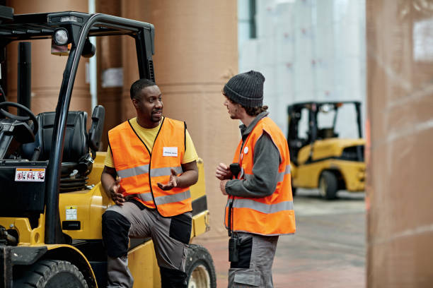 istock Forklift Driver Talking with Coworker in Distribution Center 1318116733