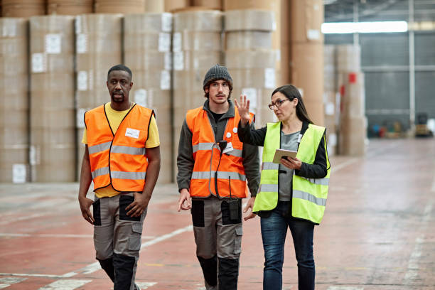 istock Female Foreperson Directing Male Warehouse Workers 1318116745