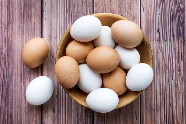 istock Wooden bowl with brown and white chicken eggs 1318119045