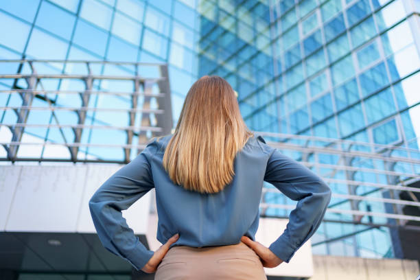 istock Back view woman looking business building 1318119096