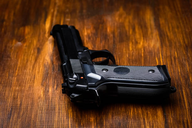 istock black gun on wooden table 1318121292