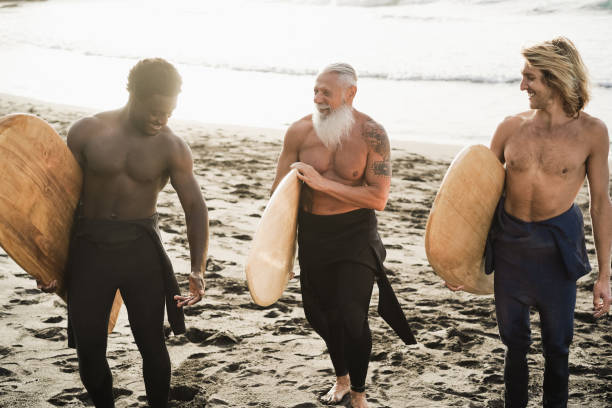 istock Multi generational surfer men having fun on the beach - Main focus on senior face 1318122360