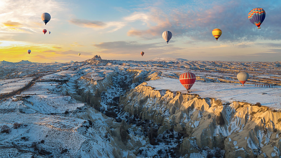 Hot air balloons fly over Cappadocia in winter, Goreme, Turkey.