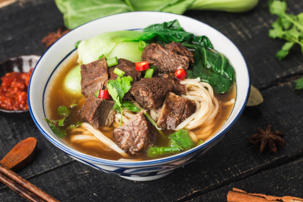 istock Spicy red soup beef noodle in a bowl on wooden table 1318125767