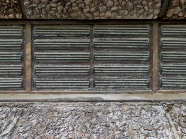 istock Ventilation grille in a granulated stone wall. 1318126783