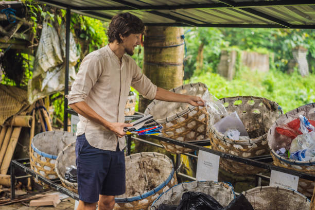 istock Man separately picks up trash. Separate garbage collection concept 1318127661