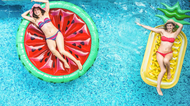 istock Happy friends having fun inside swimming pool during summer vacation - Focus on faces 1318130974
