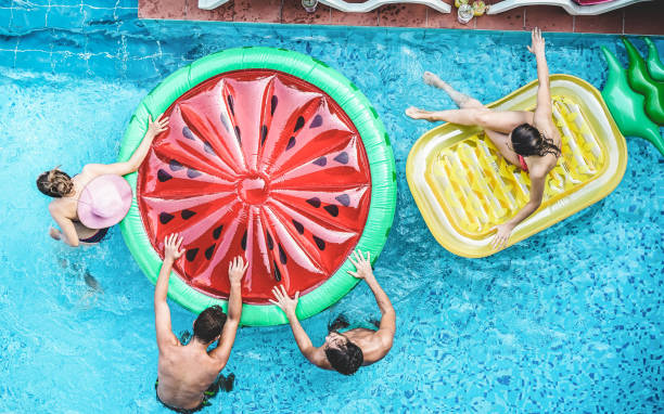 istock Happy friends having fun inside swimming pool during summer vacation - Focus on heads 1318131008