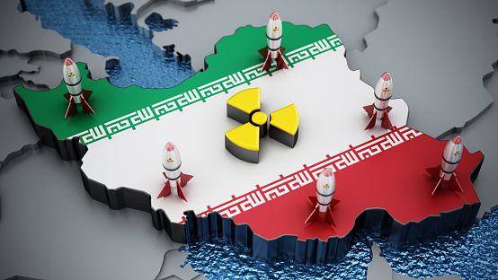Radioactive warning symbol and nuclear warheads standing on map of Iran with national flag.