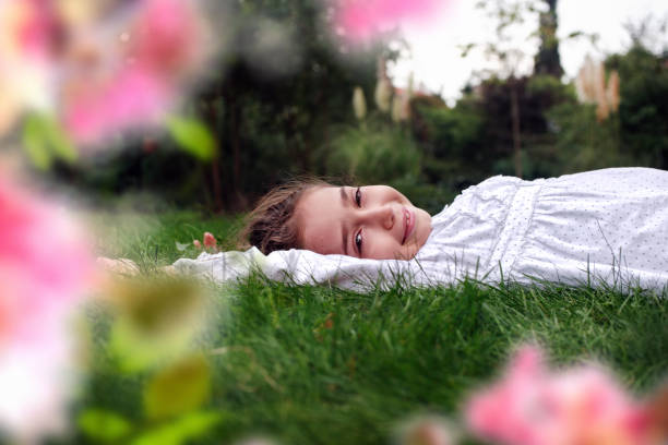 istock Happy little girl lying on green grass 1318133741