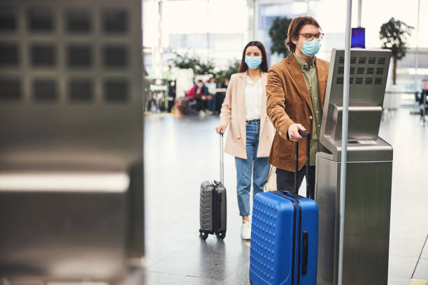 istock Man in medical mask using baggage check weighing machine at airport 1318133982
