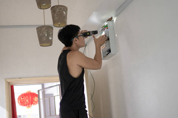 istock Asian Chinese electrician man installing electric lamp on ceiling using cordless drill. 1318134814