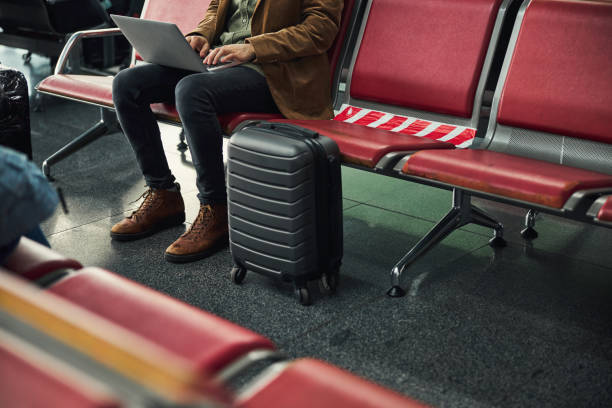 istock Stylish young man working on laptop at airport 1318134985