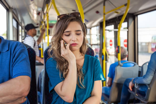 istock Sad woman talking on mobile phone in bus 1318137344