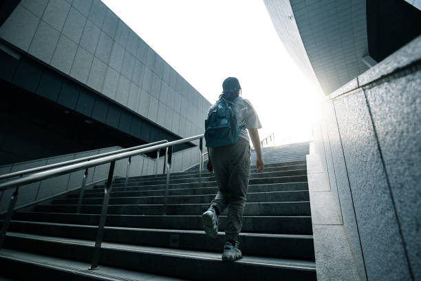 istock Young woman walking up stairs 1318137550