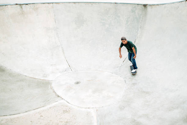 asiatische männliche skateboarding in einem skatepark - extreme skateboarding action balance motion stock-fotos und bilder