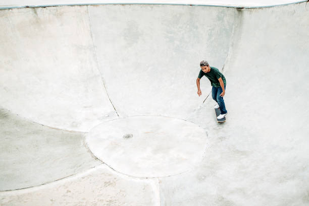skateboard asiatico maschile in uno skate park - extreme skateboarding action balance motion foto e immagini stock