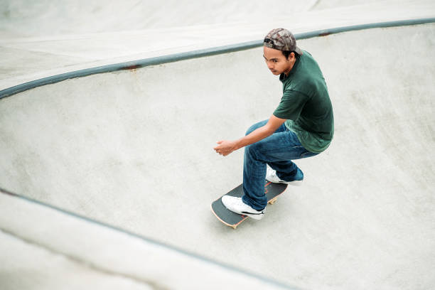 asiatische männliche skateboarding in einem skatepark - extreme skateboarding action balance motion stock-fotos und bilder