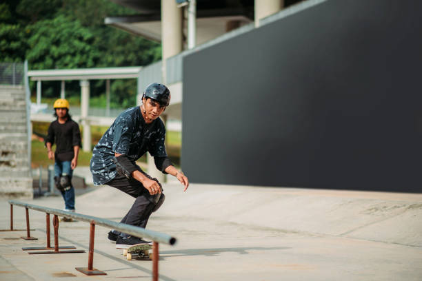 asiatische männliche skateboarding in einem skatepark - extreme skateboarding action balance motion stock-fotos und bilder