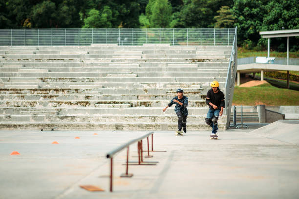 スケートパークで2人のアジアの男性スケートボード - extreme skateboarding action balance motion ストックフォトと画像