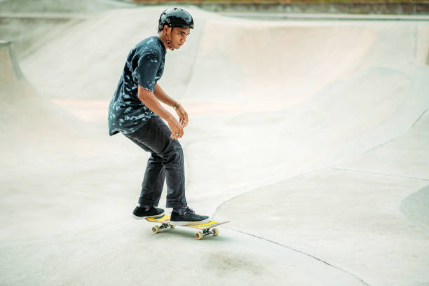 skateboard asiatico maschile in uno skate park - extreme skateboarding action balance motion foto e immagini stock