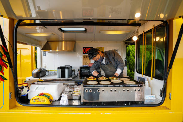 hombre maduro haciendo tacos en su camión de comida - taco alimento fotos fotografías e imágenes de stock