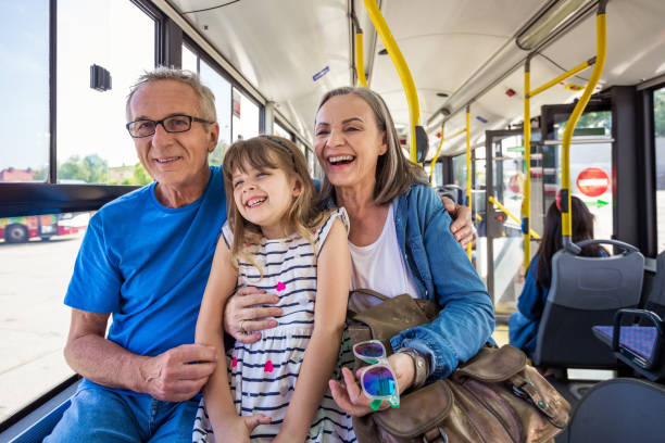 alegre niña viajando con abuelos en autobús - grandmother generation gap senior adult granddaughter fotografías e imágenes de stock
