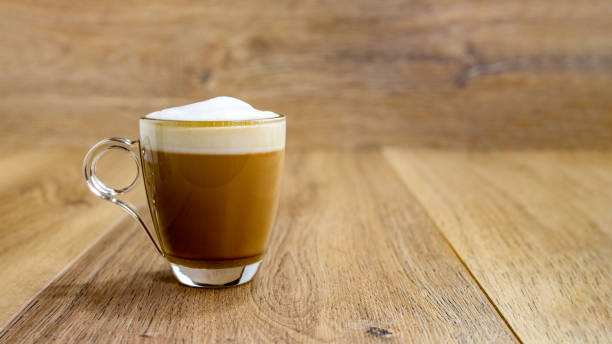 cappuccino in glass cup on wooden table, panorama on the left cappuccino in glass cup on wooden table and background, panorama macchiato stock pictures, royalty-free photos & images