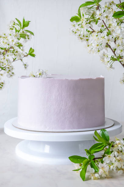 istock Wedding pink cake cake on a stand among branches of cherry blossoms 1318145333