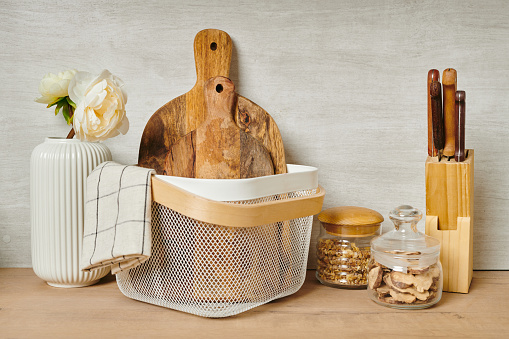 Wooden chopping boards in a white bucket and other stuff by wall