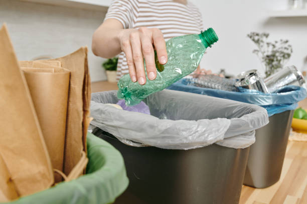 istock A person holding plastic bottle over trash bin in the kitchen 1318146187