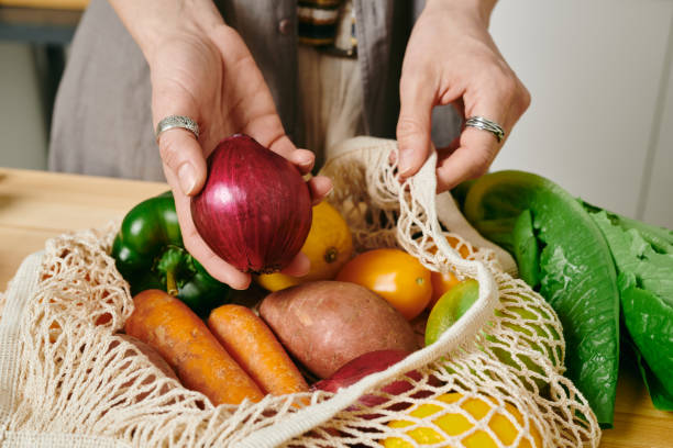 istock A person holding fresh onion over bag with other vegetables 1318146189