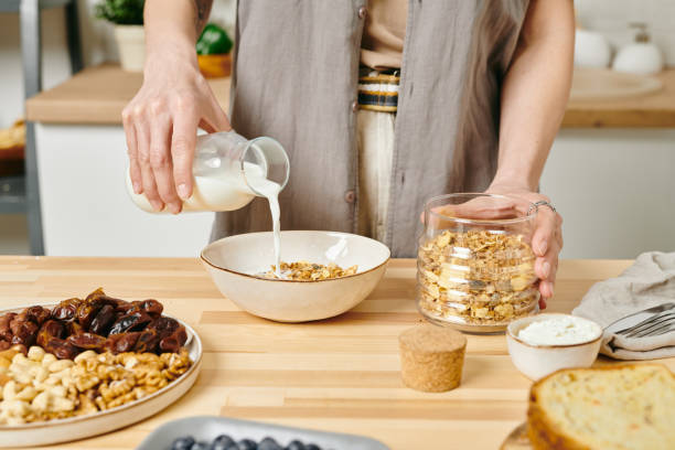 istock A woman pouring milk into bowl with corn flakes 1318146255