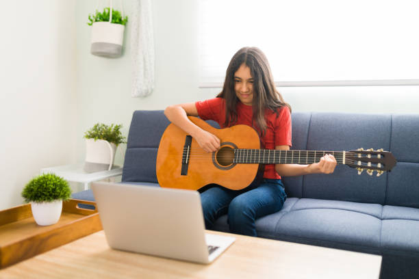 istock Playing the guitar for my online instructor 1318147317