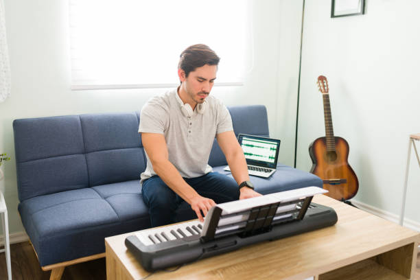 istock Young man practicing his new music on the keyboard 1318147671